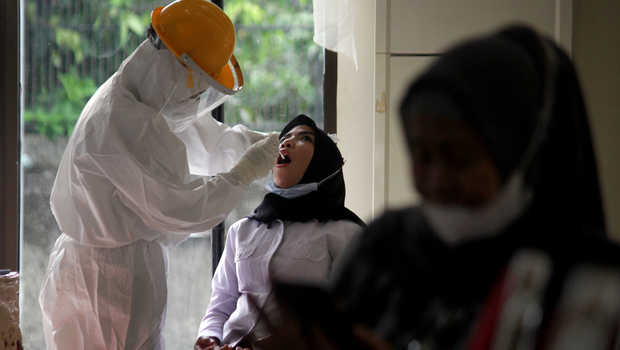 Seorang perempuan menjalani tes usap (swab test) gratis di Kabupaten Gowa, Sulawesi Selatan, Rabu (16/12/2020) Kasus Positif Covid-19 dari PTM di Bandung Capai 229 Orang